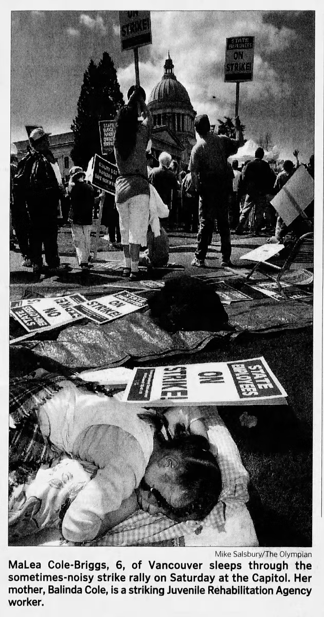 MaLea Cole-Briggs, 6, of Vancouver sleep through the sometimes-noisy strike on Saturday at the Capitol. Her mother, Balinda Cole, is a striking Juvenile Rehabilitation Agency worker.