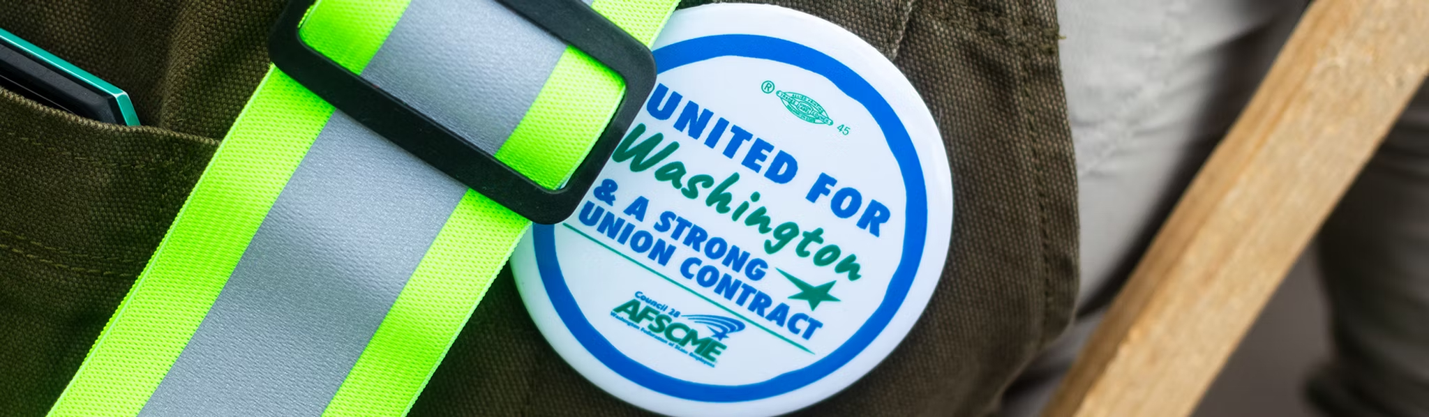 A member wearing a "United for Washington & a Strong Union Contract" button